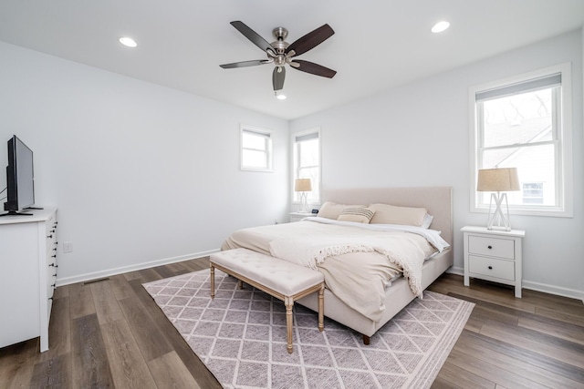 bedroom with baseboards, recessed lighting, wood finished floors, and visible vents