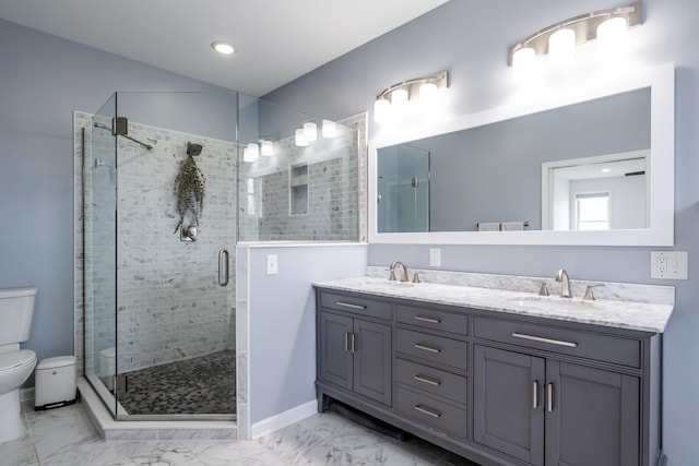 bathroom with a sink, a stall shower, toilet, and double vanity
