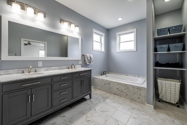 full bath with double vanity, ceiling fan, a bath, a sink, and marble finish floor