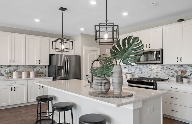 kitchen featuring a kitchen island, white cabinetry, appliances with stainless steel finishes, and tasteful backsplash
