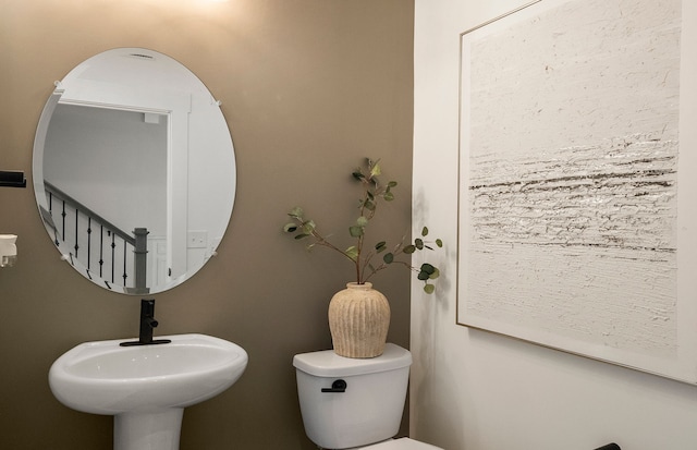 half bath featuring toilet and a sink