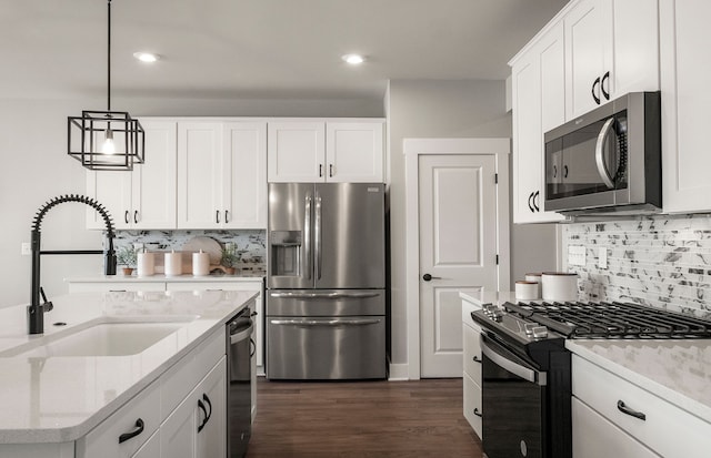 kitchen with a sink, decorative backsplash, white cabinetry, and stainless steel appliances