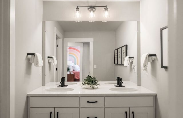 full bathroom with connected bathroom, double vanity, and a sink