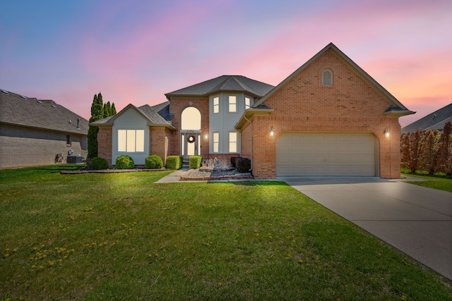 traditional-style house featuring a garage, concrete driveway, a front yard, and brick siding