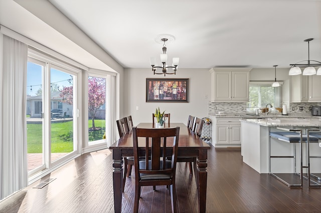 dining space featuring dark wood-style floors and a chandelier
