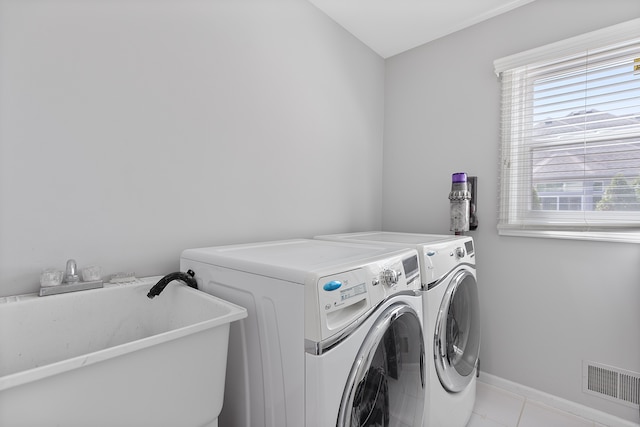 washroom with laundry area, visible vents, washing machine and clothes dryer, a sink, and light tile patterned floors