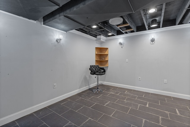 finished basement featuring baseboards and crown molding