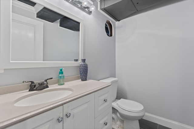 half bathroom featuring vanity and toilet