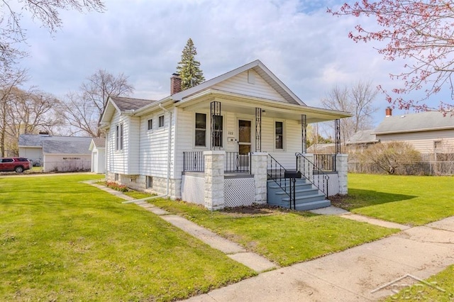 bungalow-style house featuring covered porch, a chimney, and a front lawn