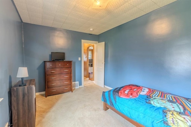 bedroom featuring baseboards, light carpet, and visible vents