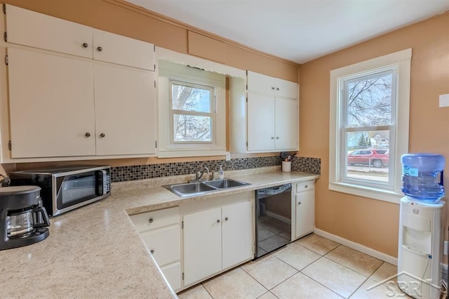 kitchen featuring black dishwasher, a healthy amount of sunlight, a sink, and tasteful backsplash