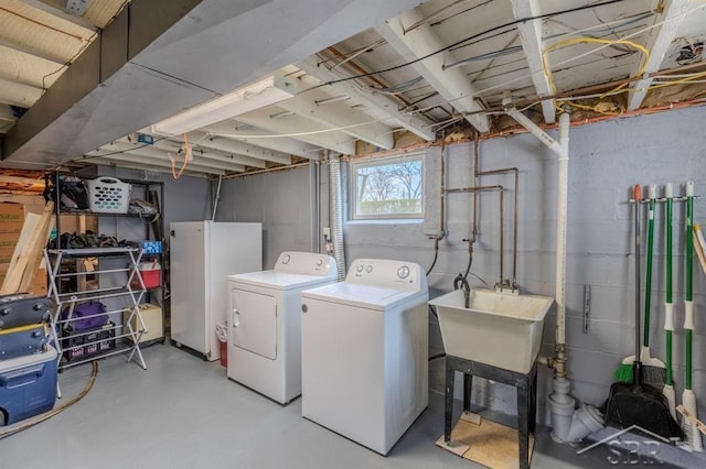 clothes washing area featuring laundry area, a sink, and washing machine and clothes dryer