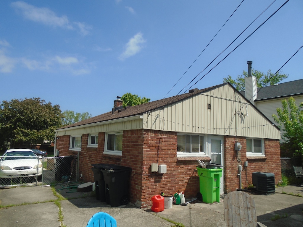26575 Barnes St, Roseville, MI 48066 - view of home's exterior featuring a chimney, fence, cooling unit, and brick siding