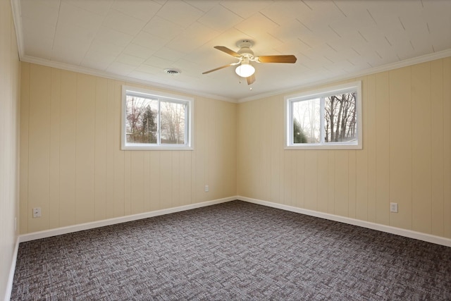 spare room with carpet floors, ornamental molding, ceiling fan, and visible vents