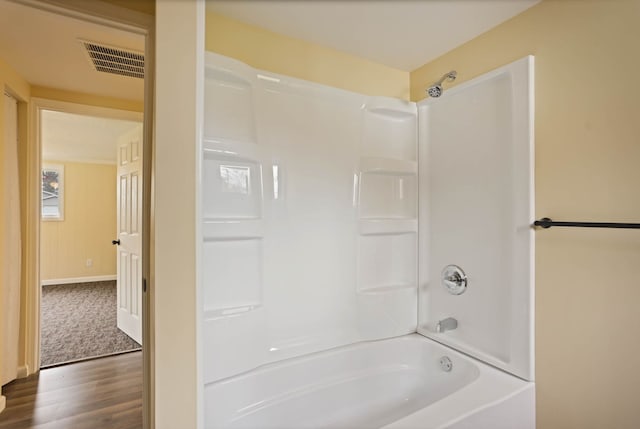 full bath featuring shower / bath combination, wood finished floors, and visible vents