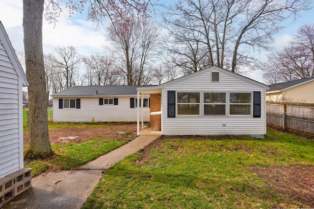 view of front of home with fence and a front lawn