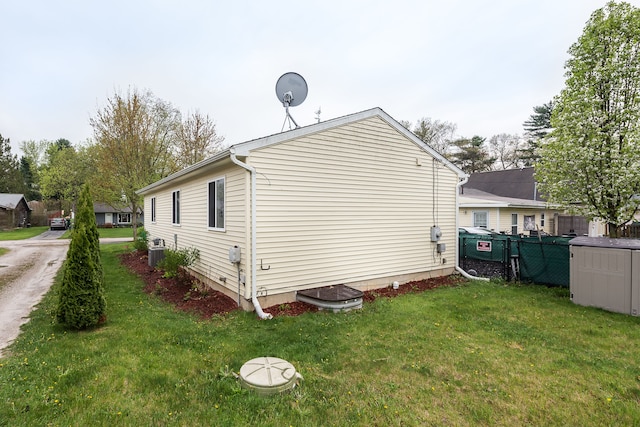 view of property exterior with central air condition unit, a lawn, and fence