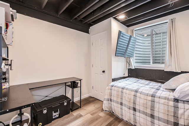 bedroom with baseboards and wood finished floors