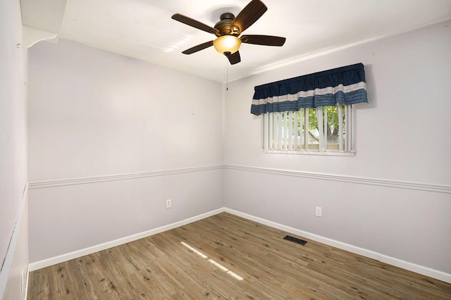 unfurnished room featuring ceiling fan, baseboards, visible vents, and wood finished floors