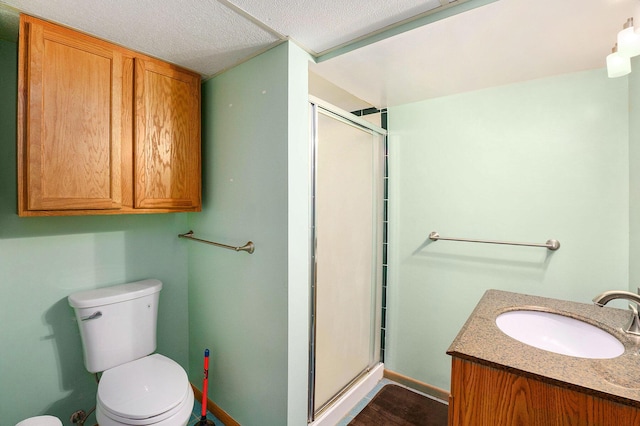 full bathroom with vanity, baseboards, a stall shower, and toilet