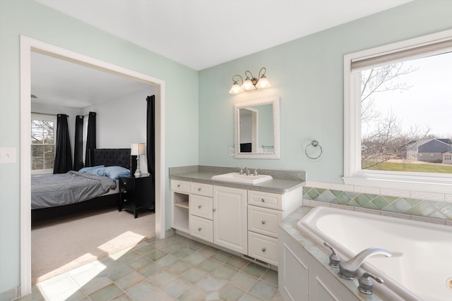 ensuite bathroom featuring vanity, ensuite bathroom, and a garden tub