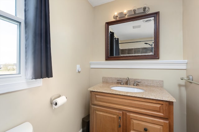 bathroom with toilet, visible vents, and vanity