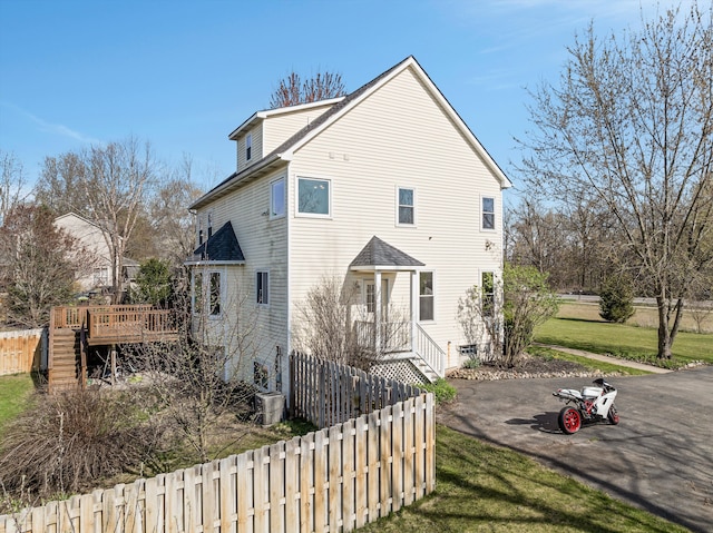 exterior space featuring stairway, fence, a yard, and a wooden deck