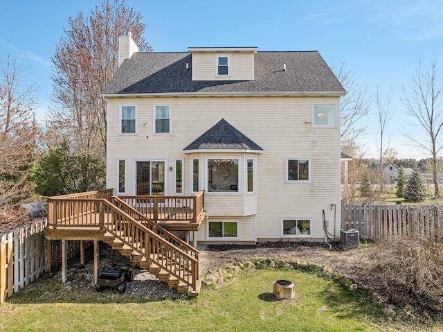 rear view of house with a lawn, a fenced backyard, a deck, and stairway