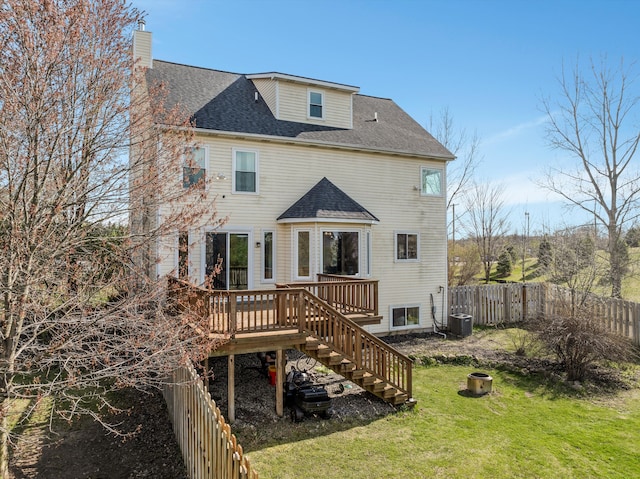 rear view of property with a chimney, a lawn, central AC unit, a fenced backyard, and stairs