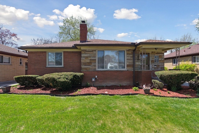 view of front facade with a chimney, a front lawn, and brick siding