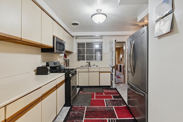 kitchen featuring a sink, white cabinetry, appliances with stainless steel finishes, and light countertops