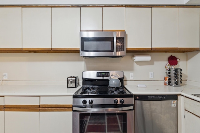 kitchen with light countertops, appliances with stainless steel finishes, and white cabinets