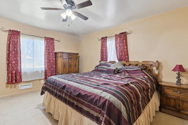bedroom with baseboards, a ceiling fan, multiple windows, and light carpet