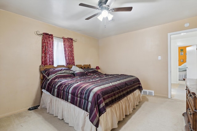 bedroom featuring baseboards, light colored carpet, ceiling fan, and visible vents