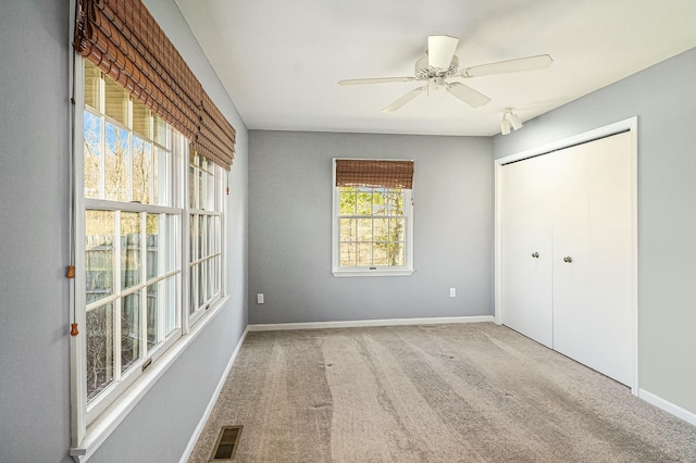 unfurnished bedroom featuring visible vents, a closet, baseboards, ceiling fan, and carpet flooring