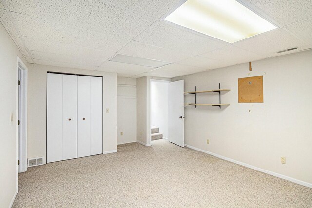 unfurnished bedroom featuring visible vents, a paneled ceiling, and light colored carpet