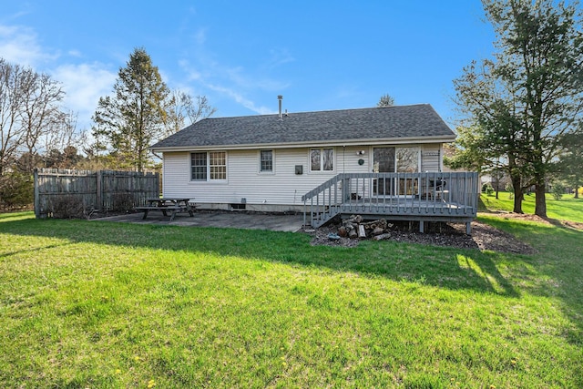 back of house featuring a yard, a deck, fence, and a patio area