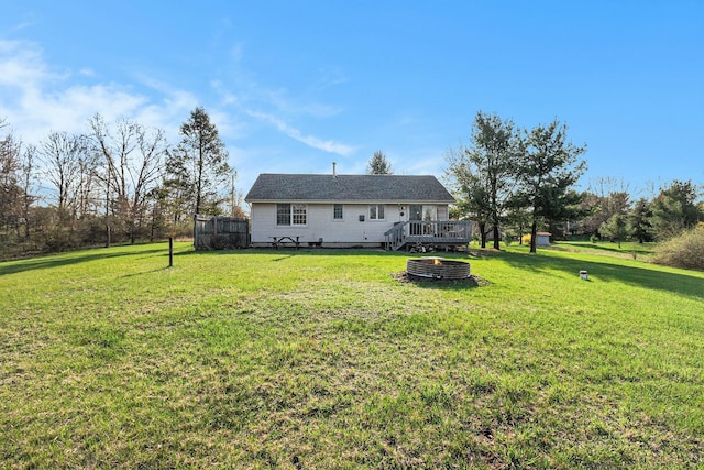rear view of house featuring a yard and a deck