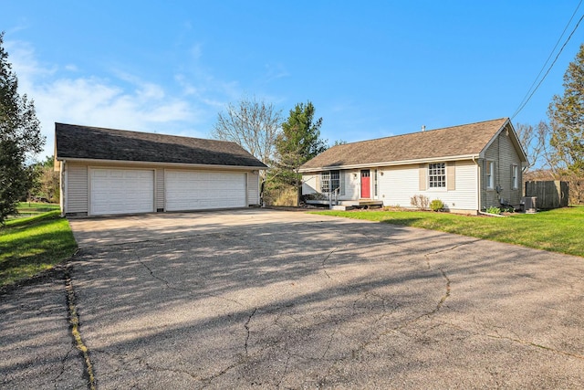ranch-style house featuring central AC, a front lawn, an outdoor structure, and a garage