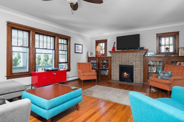 living room featuring ornamental molding, ceiling fan, wood finished floors, and a healthy amount of sunlight