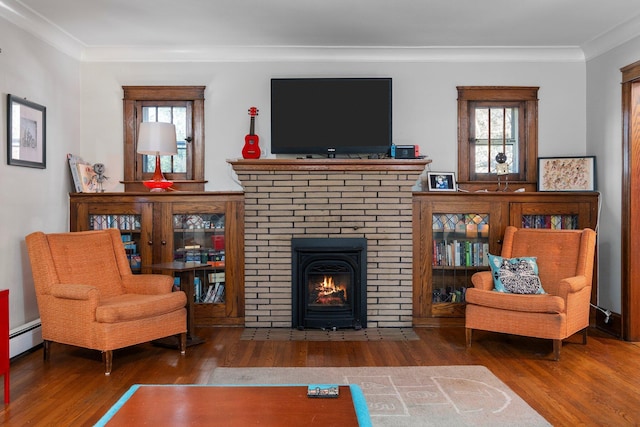 sitting room featuring a brick fireplace, ornamental molding, wood finished floors, and plenty of natural light