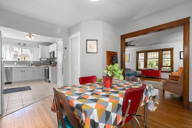 dining area with light wood-style flooring, ceiling fan, and a wealth of natural light