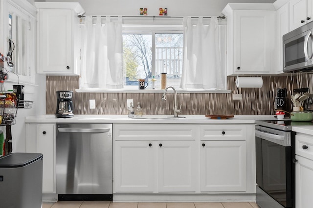 kitchen featuring light countertops, white cabinets, a sink, light tile patterned floors, and stainless steel appliances