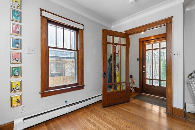 foyer entrance with plenty of natural light, a baseboard radiator, and wood finished floors