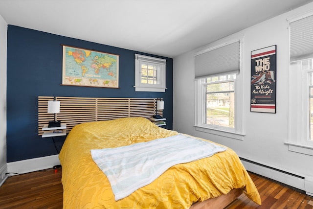 bedroom featuring baseboards, baseboard heating, and wood finished floors