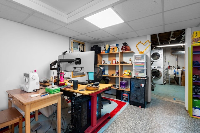 home office featuring stacked washer / drying machine and a paneled ceiling