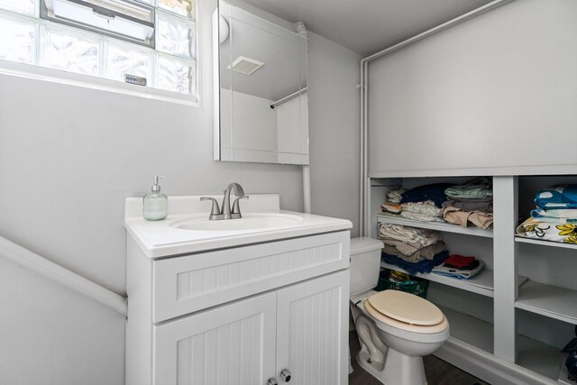 bathroom featuring vanity, toilet, and visible vents