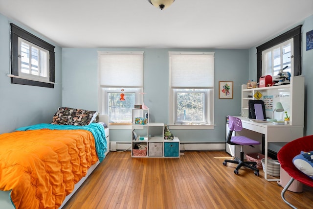 bedroom with hardwood / wood-style floors and a baseboard radiator
