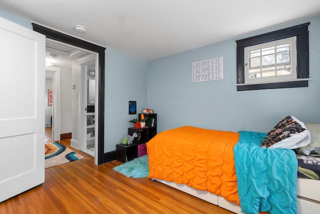 bedroom with baseboards and wood finished floors