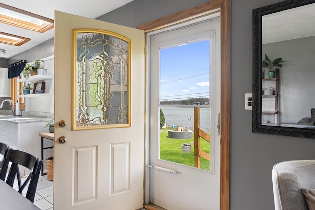 entryway featuring a water view and light tile patterned floors